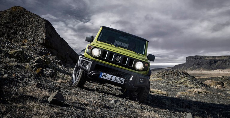 Suzuki Jimny Hybrid in Kinetic Yellow im Gelände - Licht an.