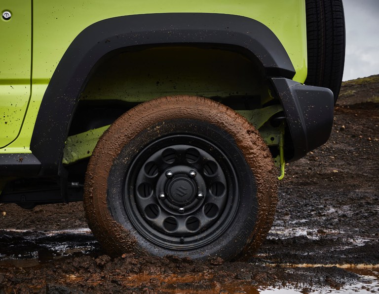 Detailaufnahme eines Hinterreifens eines Suzuki Jimny Hybrid in Kinetic Yellow.